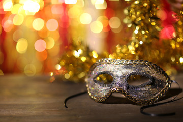 Beautiful carnival mask on table on bright background