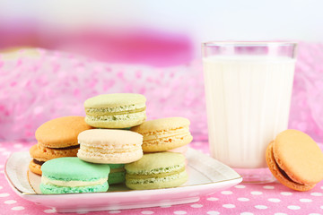 Gentle colorful macaroons and milk glass on bright background
