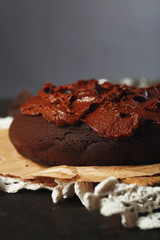Chocolate cake with chocolate cream on wooden table close-up