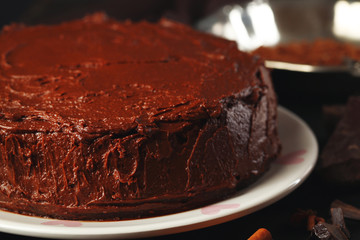 Chocolate cake with chocolate cream on wooden table close-up
