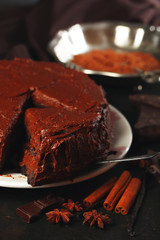 Chocolate cake with chocolate cream on wooden table close-up