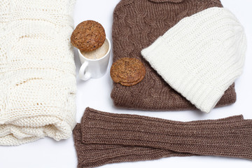 Obraz na płótnie Canvas Winter clothes with a cup of cappuccino and biscuits