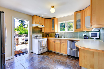 Modern light tone kitchen room with exit to backyard
