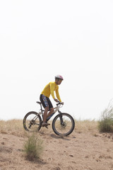 Naklejka premium man riding mountain bike on dirt field