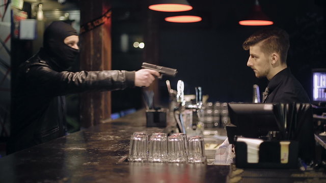 Unsuccessful robbery bar. The barman also has a gun