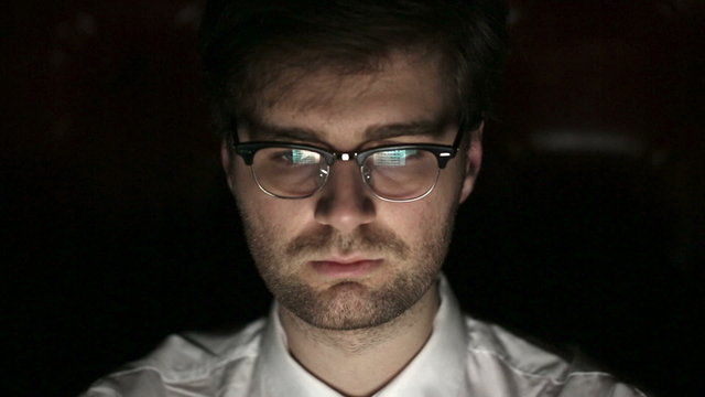Portrait of a young man with glasses who works at night.
