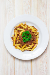 Penne pasta with a tomato bolognese beef sauce on wood table top