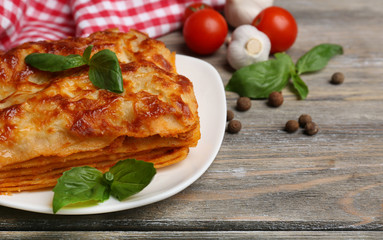 Portion of tasty lasagna on wooden table