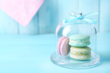 Gentle colorful macaroons in glass bell jar