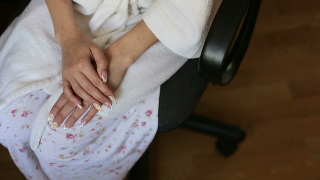 Hands of a young girl who is sitting on a chair