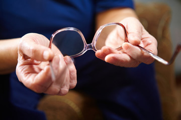 Old woman hands with eyeglasses