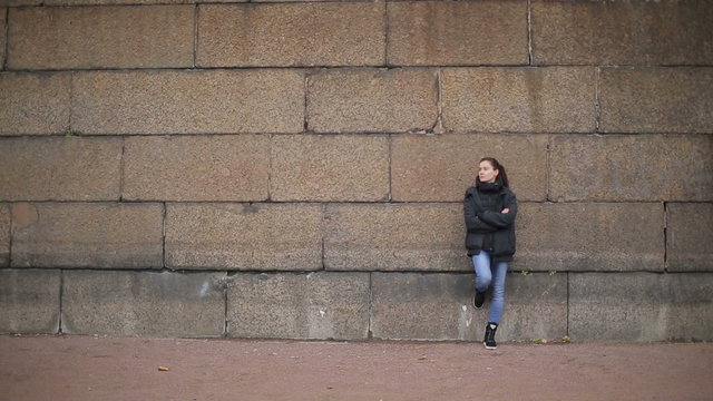 ong shot of the girl near the stone wall
