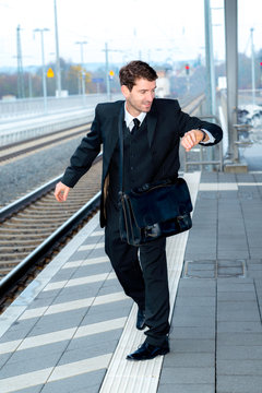 businessman on railroad station in hastiness
