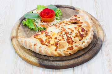 Calzone pizza on wooden dish - 74221682