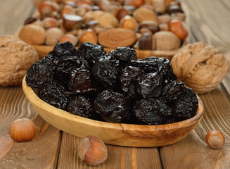 Dried prunes in a wooden bowl