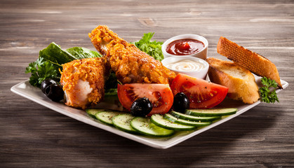 Fried chicken drumsticks and vegetables