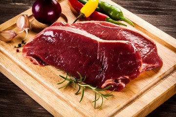 Raw beef on cutting board and vegetables