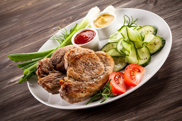 Barbecued steak, boiled potatoes and vegetable salad