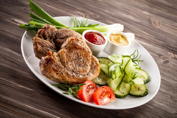 Barbecued steak, boiled potatoes and vegetable salad