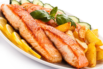 Grilled salmon and vegetables on white background