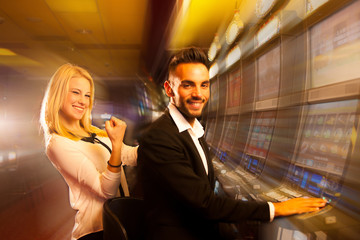 young couple winning on slot machine in casino
