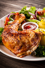 Barbecued chicken leg with boiled potatoes and vegetables