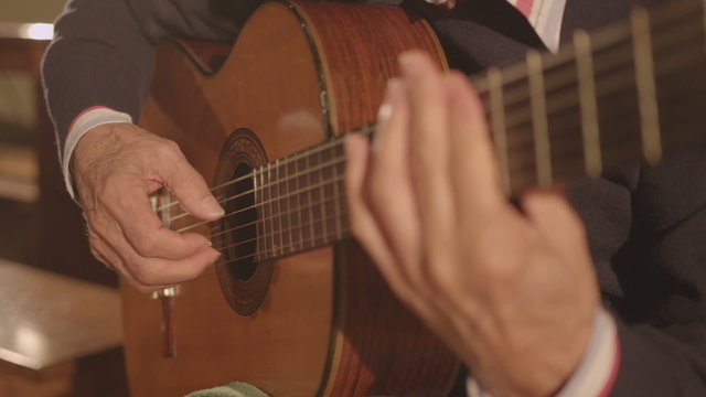 Classical guitarist playing an arpeggio on classic guitar