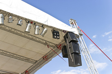 Outdoor concert stage roof construction with speakers  over sky