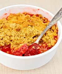 Crumble strawberry with spoon on fabric