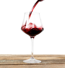 red wine glass over wood against white background