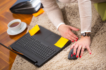 Young woman with laptop on the carpet