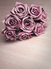 bouquet of purple roses on wooden surface