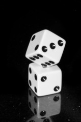 Two Stocked Dice on Reflective Granite Tabletop