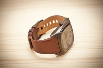 wristwatch on wooden surface