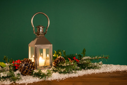 Christmas lantern hooly and snow green background