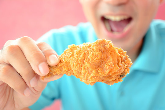 A Man With Opening Mouth About To Eat Deep Fried Chicken Leg Or