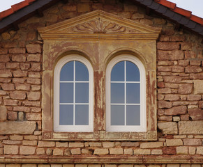 Buntsandsteinfassade mit PVC Bogenfenstern in Renovierung