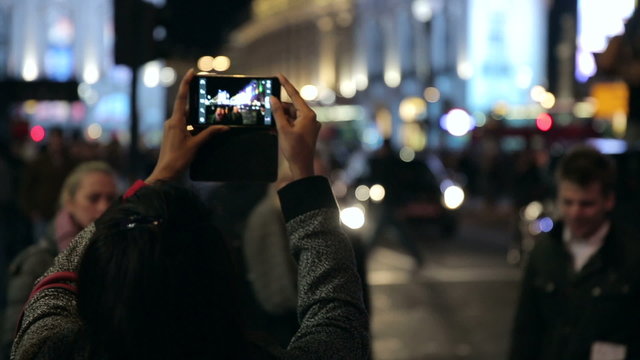 Person Taking a Picture with a Smartphone of Piccadilly Traffic and Street Scene 