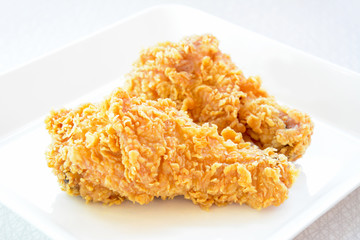 Fried chicken legs on a white plate