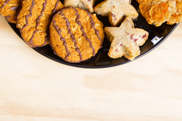 Variety of cookies on black plate.  Empty space for text