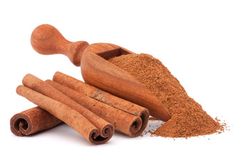 ground cinnamon spice powder in wooden spoon isolated on white b