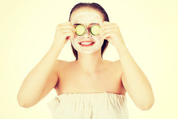 Young woman with cucumber slices