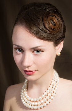 Beautiful caucasian girl,pearls necklace.Particular hairsylte.