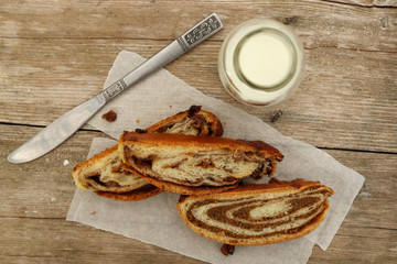 Slices of strudel with bottle of milk on wooden table