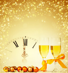 Glasses with champagne and clock close to midnight