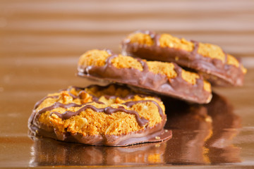 Brown cookies with chocolate strips on yellow glossy paper