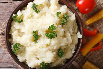 Hot mashed potatoes with parsley and vegetables, top view