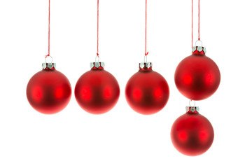 Red Christmas balls hanging at a rope over white