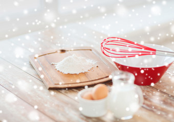 close up of milk jug, eggs, whisk and flour