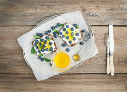 Healthy breakfast set with ricotta, fresh blueberries, honey and